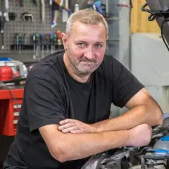 Mechanik przy otwartej masce Passata B6, który nie odpala i nie kręci.