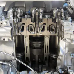 Przekrój silnika z widocznymi wtryskami common rail, tłokami i turbosprężarką.
