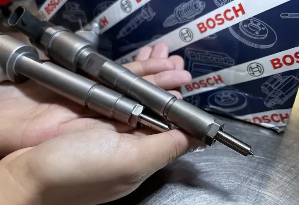 Dwie wtryskiwacze Bosch w dłoni, gotowe do montażu. Ich precyzja zapewnia samoadaptację wtryskiwaczy dla optymalnej pracy silnika.